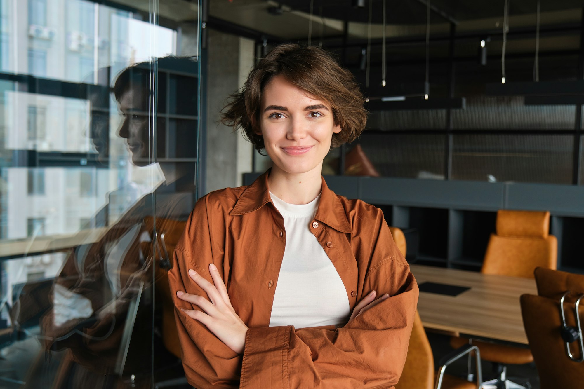 Portrait of young confident woman, start-up manager in office, posing with confidence, looking self